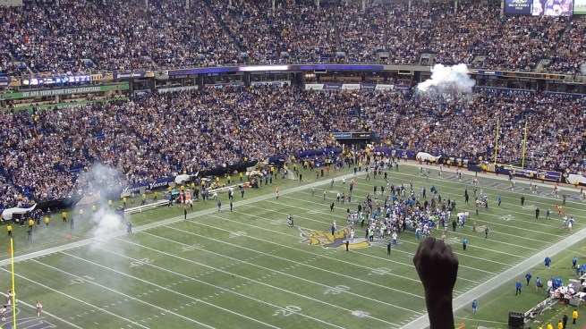 A fan raises a fist in triumph as the Vikings walk out of the Metrodome one last time as winners.